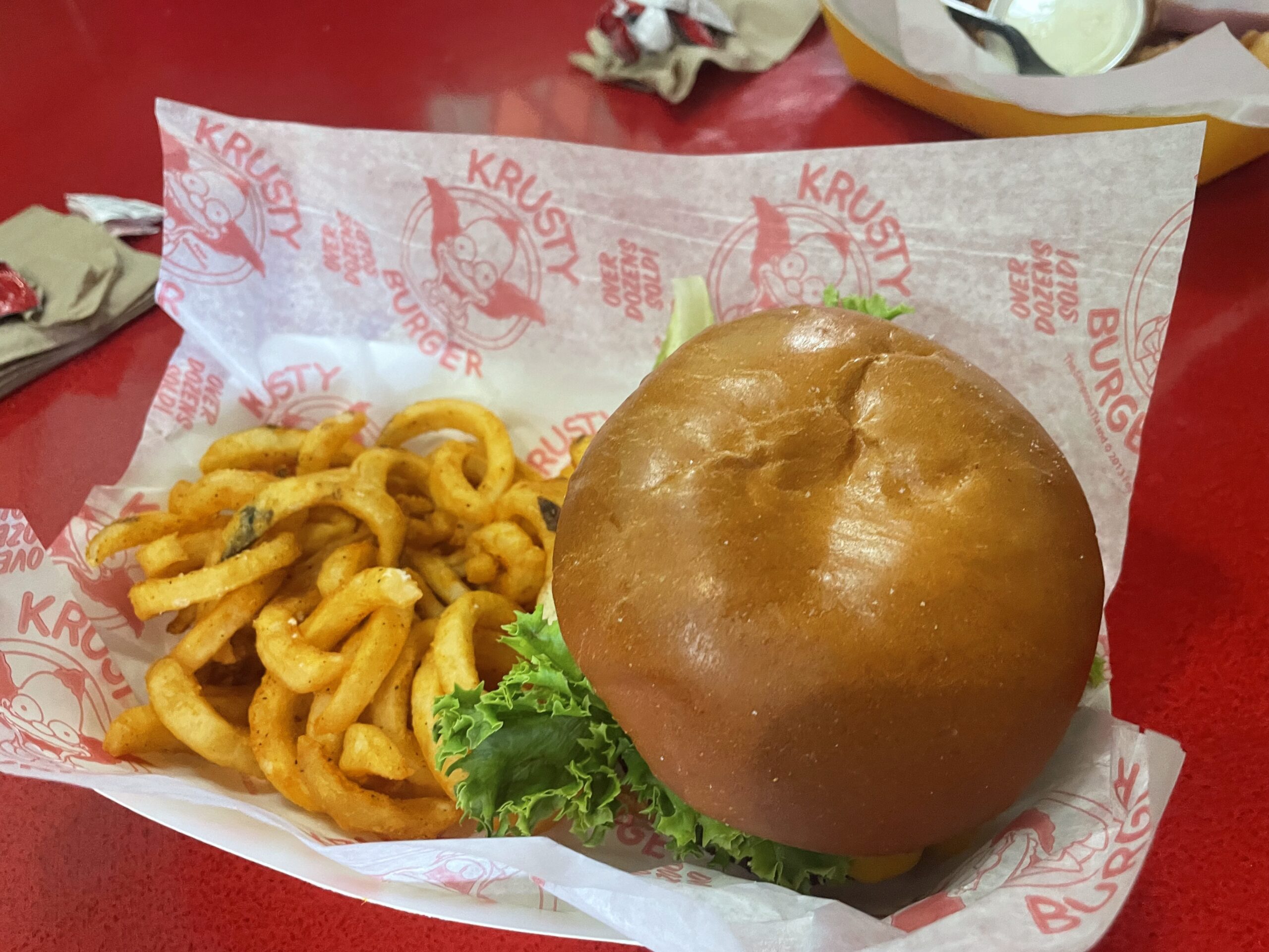 Close-up of a Krusty Burger with toppings served at Krusty Burger restaurant.