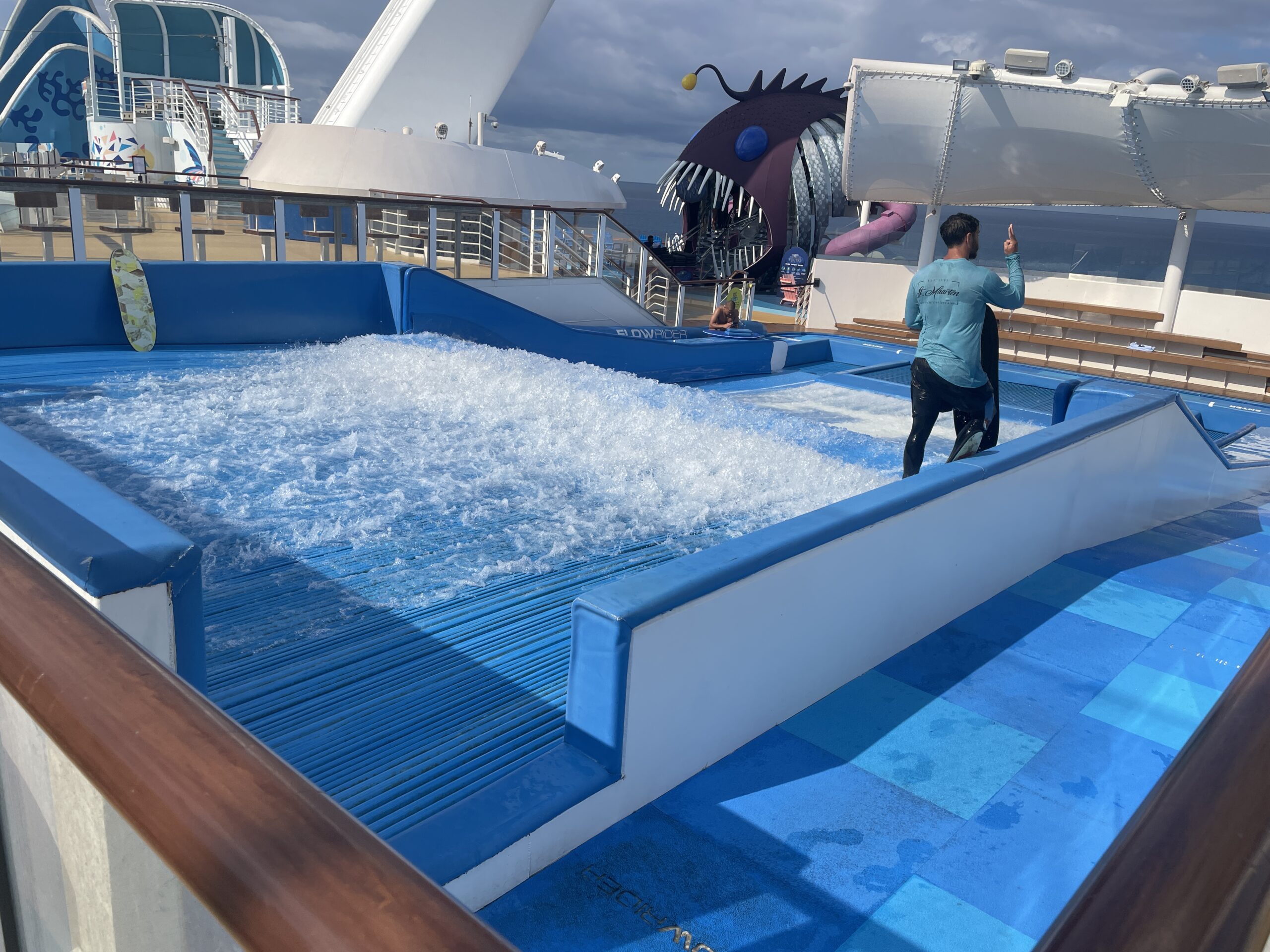 A guest surfing on the FlowRider surf simulator on the sports deck of Royal Caribbean's Wonder of the Seas.