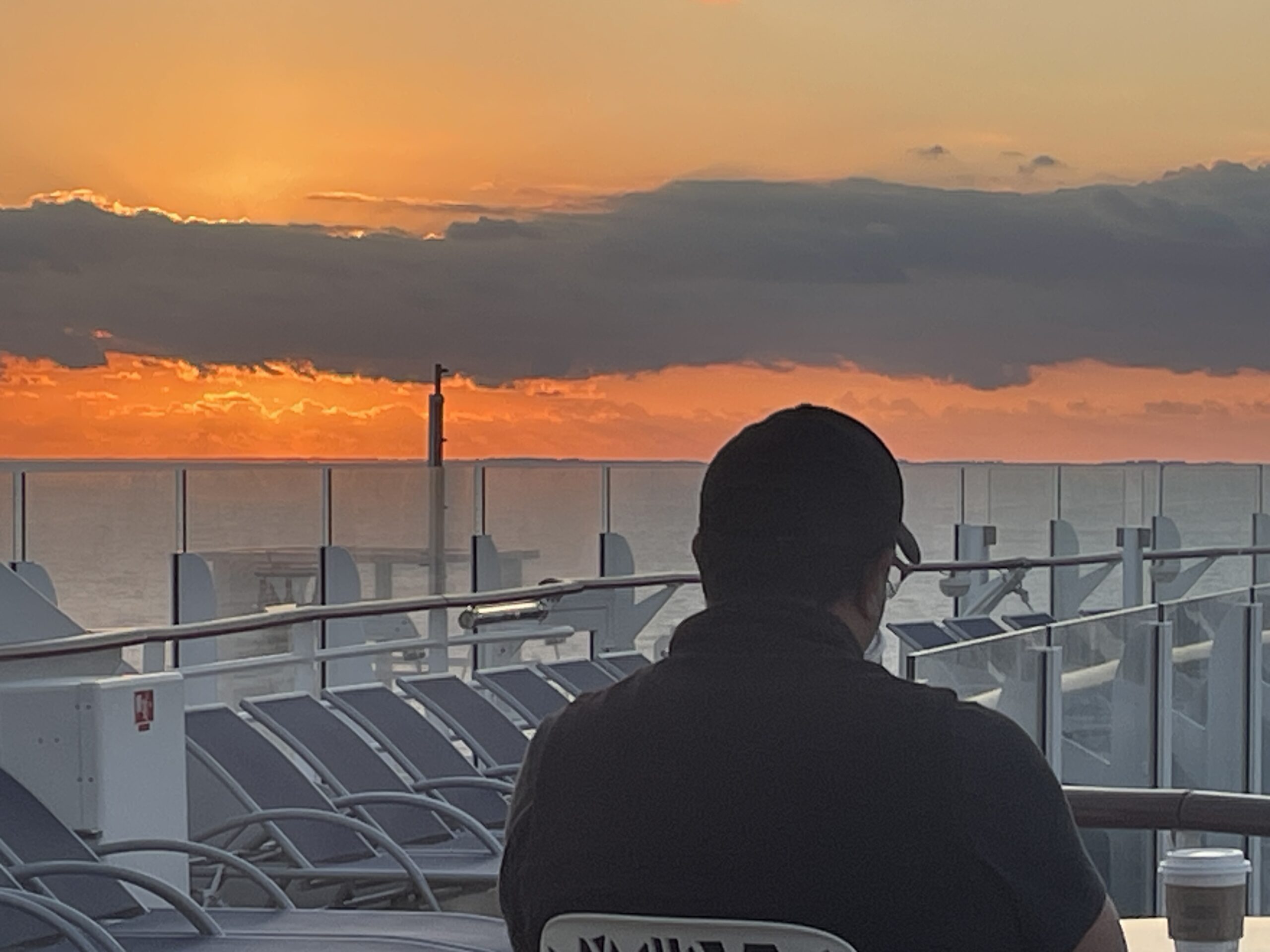 Man enjoying the sunrise on the deck of the Wonder of the Sea Royal Caribbean cruise ship