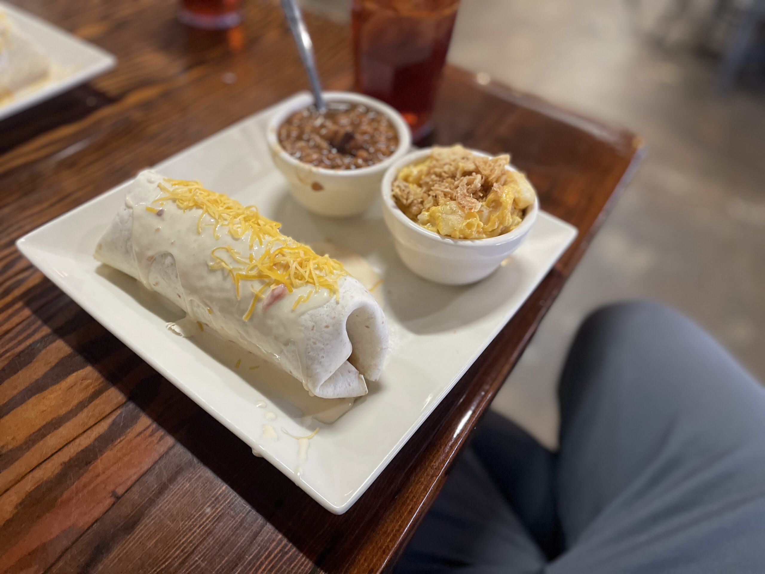 The famous BBQ Burrito at Fat Daddy's Bar-B-Que in Russellville, Arkansas, stuffed with smoked pork, beans, and coleslaw, smothered in signature cheese sauce and a side of their cheezy tators
