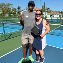 Travel agent Katy Thompson with Pickleball pro at one the pickleball courts at Sandals Resort